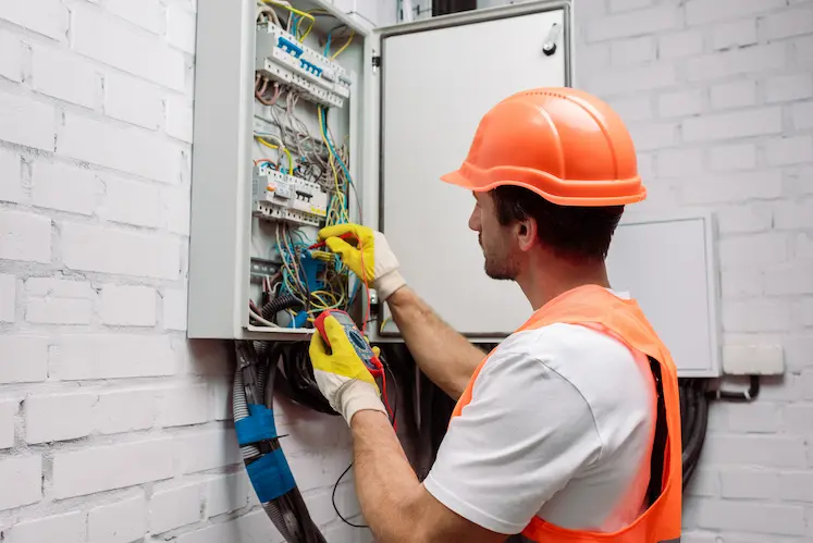 Electrician wearing a safety vest working on an electrical installation